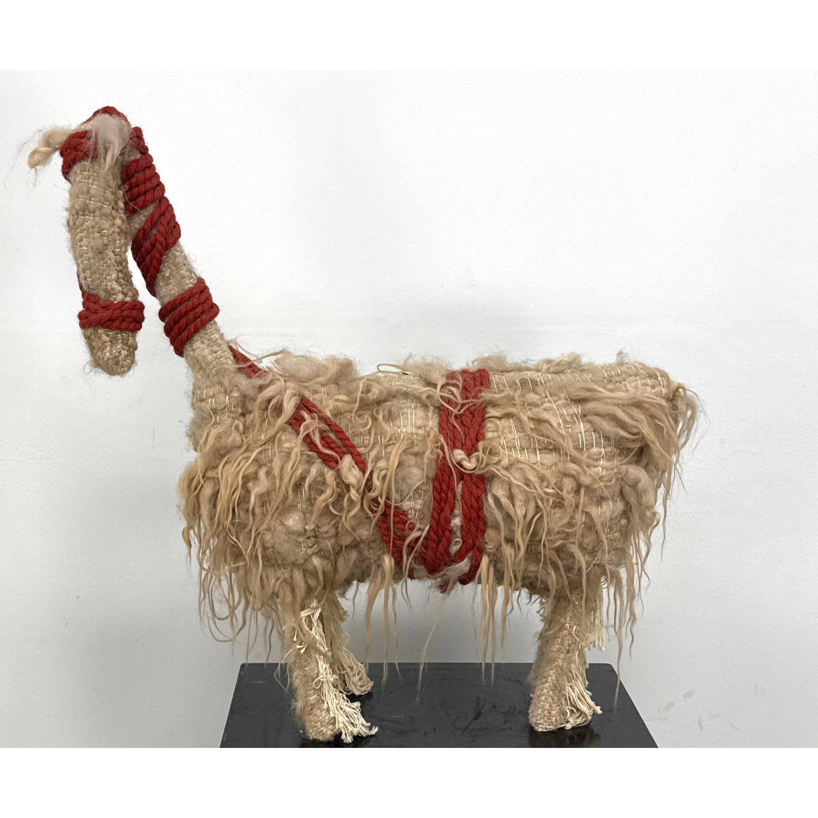 Hand Woven Textile Llama Sculpture with Shaggy Wool Fleece and Braided Red Cord Harness. Unsigned.: Hand Woven Textile Llama Sculpture with Shaggy Wool Fleece and Braided Red Cord Harness. Unsigned. Dimensions: Height: 29.5 inches, Width: 30 inches, Depth: 10 inches. ---