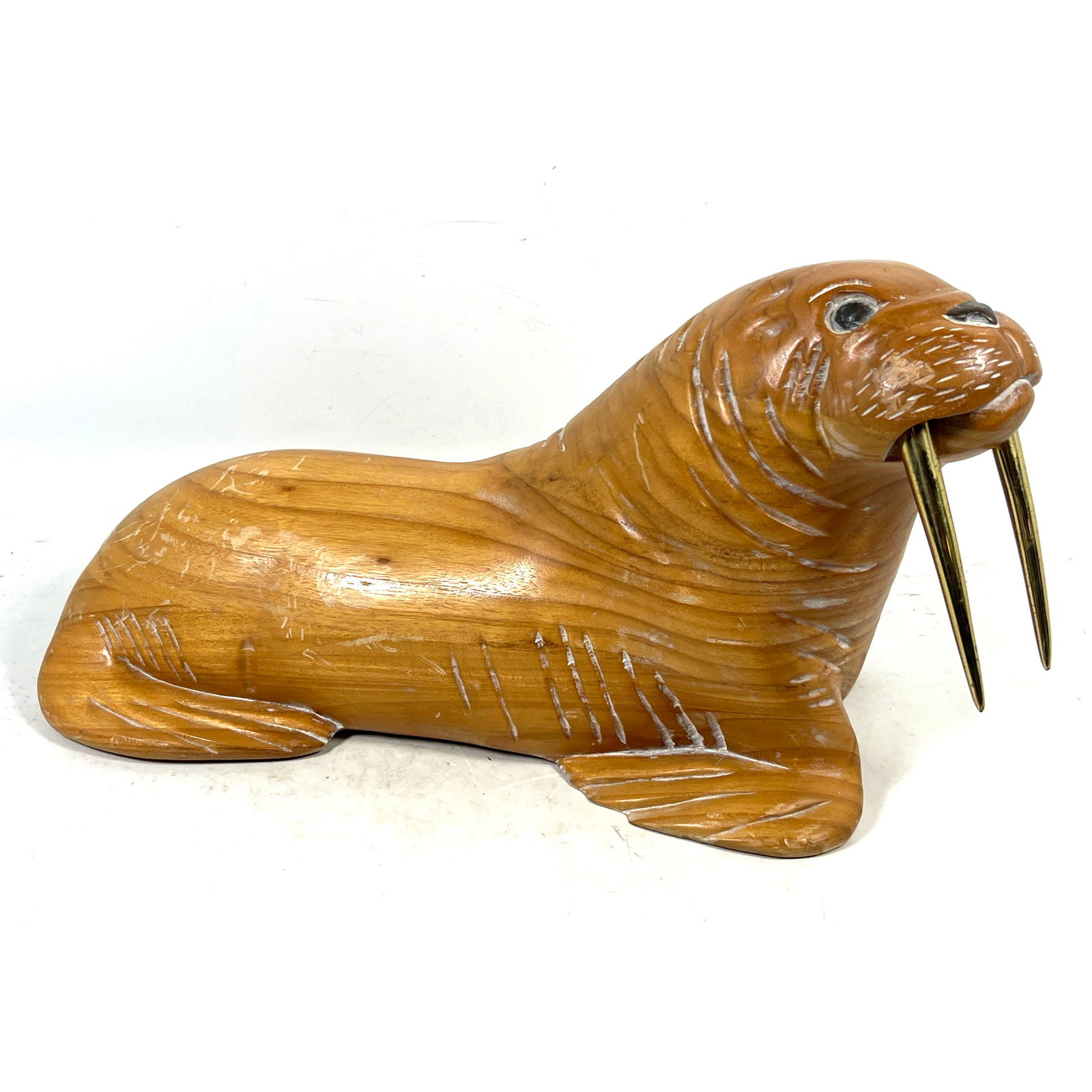 Large Hand Carved Wooden Walrus Sculpture with Gold Toned Metal Tusks.: Large Hand Carved Wooden Walrus Sculpture with Gold Toned Metal Tusks. Dimensions: Height: 13 inches, Width: 22 inches, Depth: 11 inches. --- US Packing and Shipping charge: In house shipping
