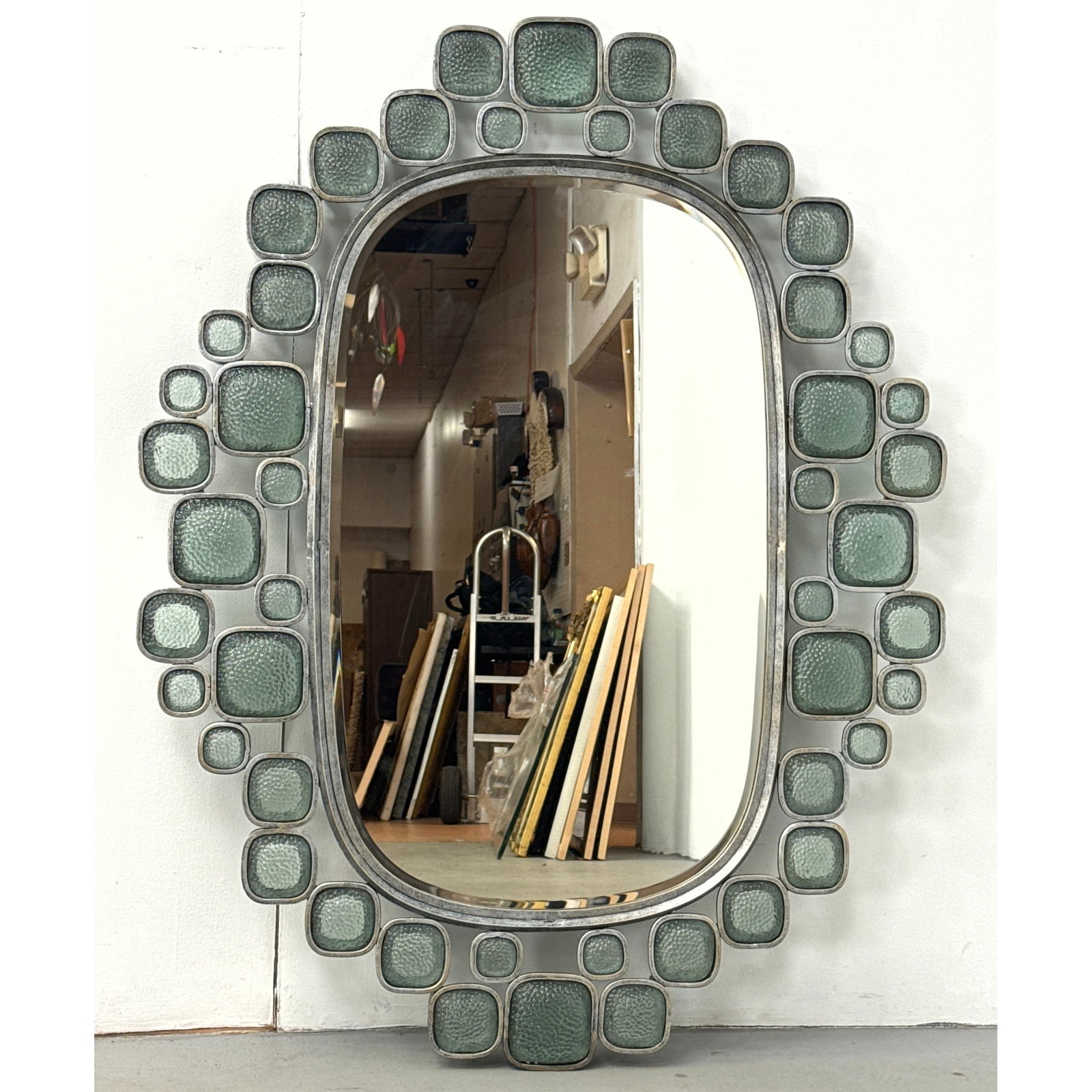 Large Oval Modernist Brutalist Wall Mirror with Antiqued Silver Tone Metal Frame and Inset Textured: Large Oval Modernist Brutalist Wall Mirror with Antiqued Silver Tone Metal Frame and Inset Textured Green Glass Panels. Contemporary. Dimensions: Height: 40 inches, Width: 51 inches, Depth: 2 inches. 