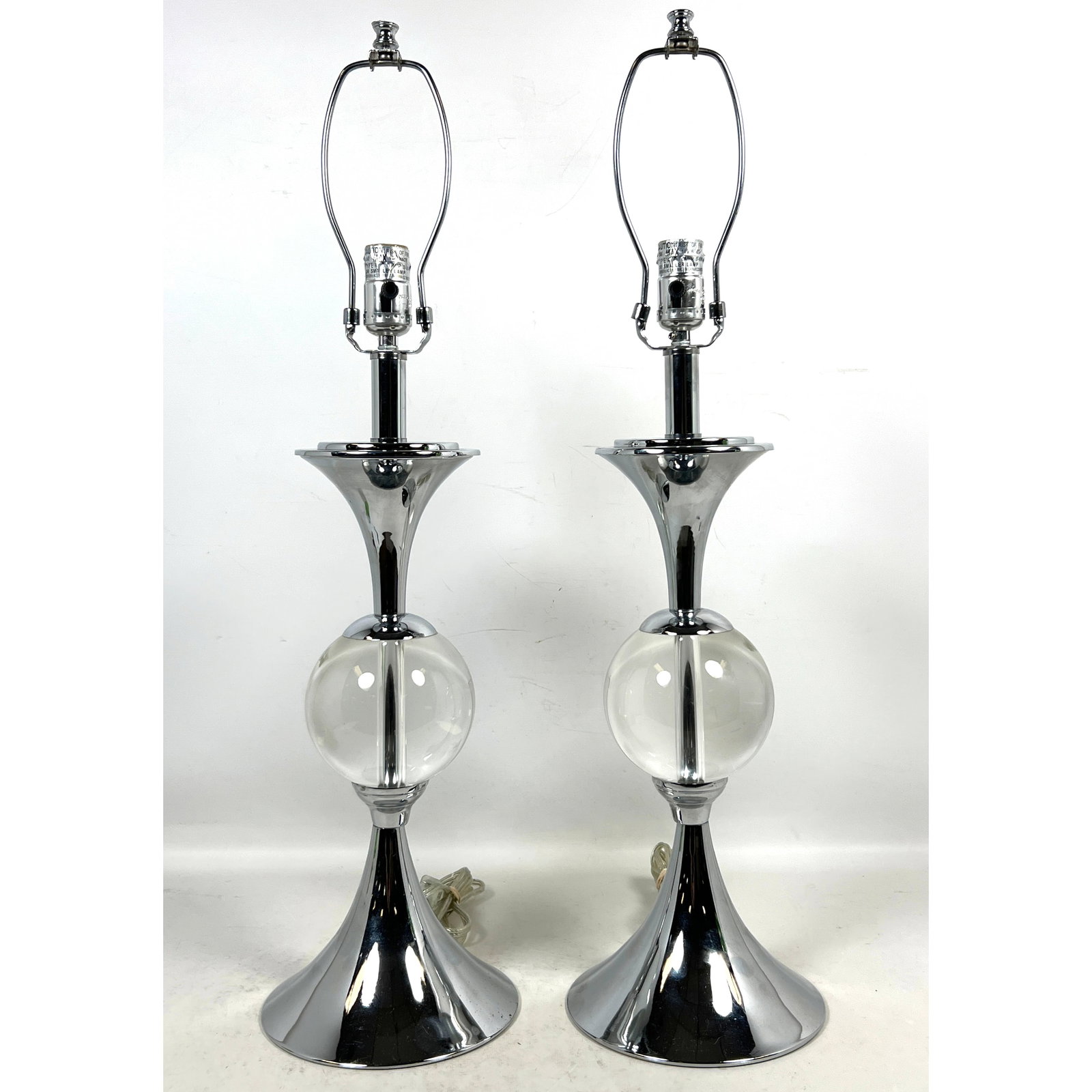 Pair contemporary chrome and clear glass sphere table lamps in the modernist style with trumpet base: Pair contemporary chrome and clear glass sphere table lamps in the modernist style with trumpet bases Dimensions: Height: 28 inches, Width: 7.5 inches, Depth: 7.5 inches. ---