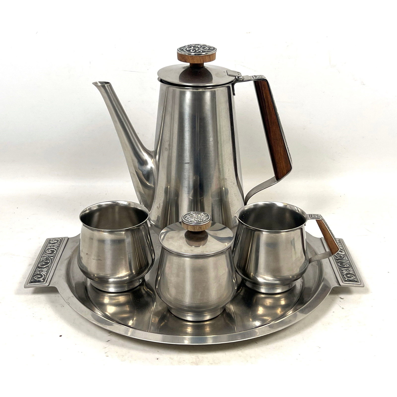 International Decorator Stainless Steel 5pc Coffee and Tea Service with wood accents and floral meda: International Decorator Stainless Steel 5pc Coffee and Tea Service with wood accents and floral medallions Dimensions: Height: 10 inches, Width: 8 inches, Depth: 4 inches. --- US Packing and Shipping 