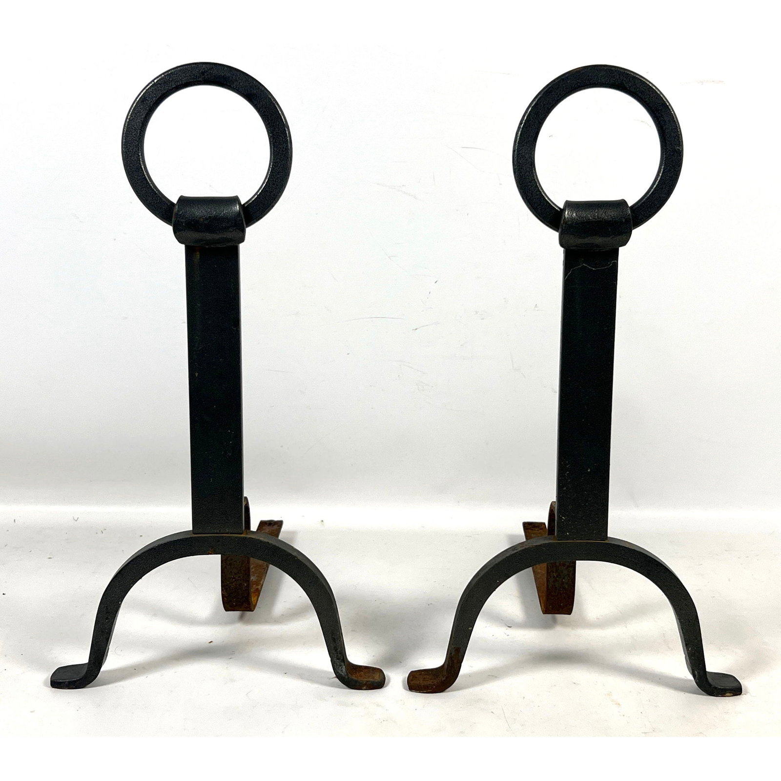 Pair of Wrought Iron Modernist Andirons with Large Ring Finials in the Style of Pilgrim Blacksmith: Pair of Wrought Iron Modernist Andirons with Large Ring Finials in the Style of Pilgrim Blacksmith Dimensions: Height: 18.25 inches, Width: 10 inches, Depth: 15 inches. ---
