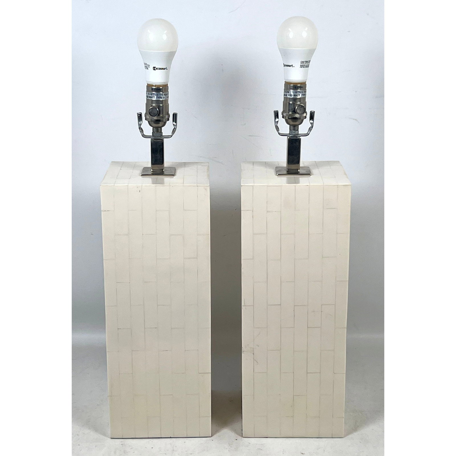 Pair of Mid-Century Modern Style Tessellated Bone Column Table Lamps with Polished Chrome Hardware a: Pair of Mid-Century Modern Style Tessellated Bone Column Table Lamps with Polished Chrome Hardware and Felted Bases Dimensions: Height: 26 inches, Width: 6.25 inches, Depth: 6.25 inches. ---