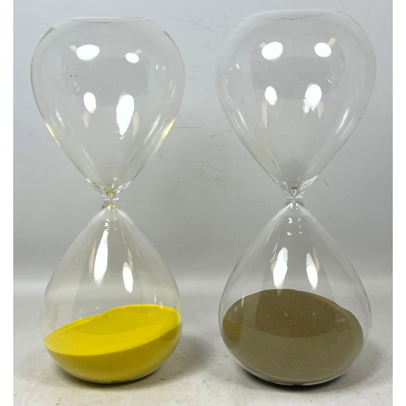 Pair of Large Contemporary Hand Blown Clear Glass Hourglasses featuring Yellow and Olive Brown Sand: Pair of Large Contemporary Hand Blown Clear Glass Hourglasses featuring Yellow and Olive Brown Sand Dimensions: Height: 16 inches, Width: 4 inches, Depth: 4 inches. --- US Packing and Shipping charge: