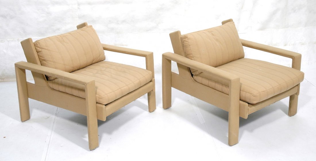 Pr fabric covered lounge chairs. Tan fabric accen: Pr fabric covered lounge chairs. Tan fabric accented with brown stitching. Open arms. Slanted back. Not marked.-- Dimensions: H: 27 inches: W: 32 inches: D: 36 inches ---