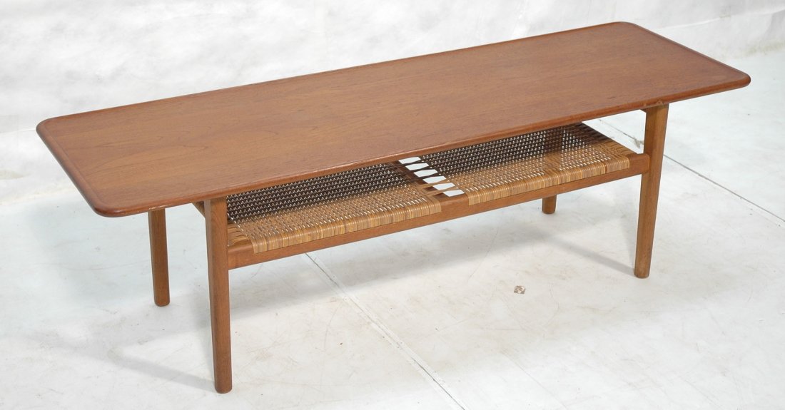Hans Wegner Coffee Cocktail Table. Raised rim To: Hans Wegner Coffee Cocktail Table. Raised rim Top over woven lower shelf. Danish modern Teak. Branded Fabrikat Andr Tuck Arkitekt Hans J. Wegner Denmark-- Dimensions: H: 19.75 inches: W: 63 inches: D: