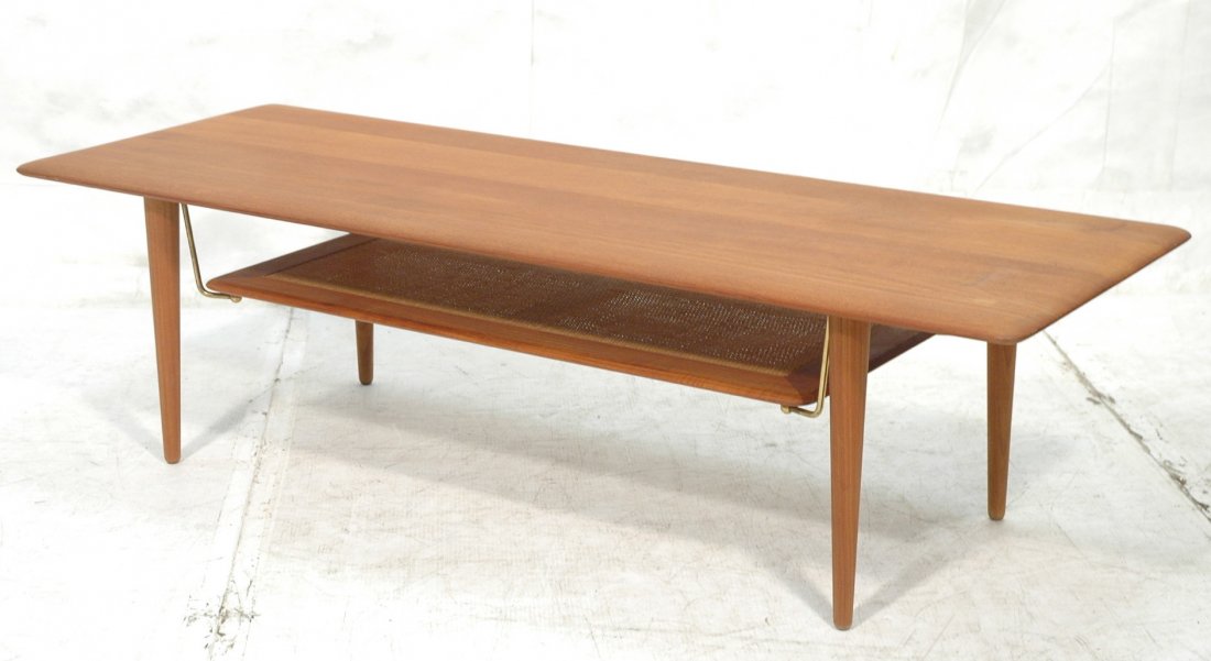 PETER HVIDT Danish Modern Teak Cocktail Table. Ta: PETER HVIDT Danish Modern Teak Cocktail Table. Tapered peg legs on coffee table. Woven lower shelf. France & Sons metal tag. -- Dimensions: H: 15.75 inches: D: 21 inches: L: 58 inches ---