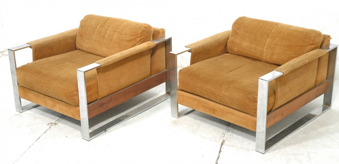Pr MILO BAUGHMAN style Chrome Frame Lounge Chairs: Pr MILO BAUGHMAN style Chrome Frame Lounge Chairs. Wood skirt sides. Dark golden fabric upholstery. Wide flat chrome frame. CARSON, manufacturer. -- Dimensions: H: 21.75 inches: W: 32 inches: D: 36 in
