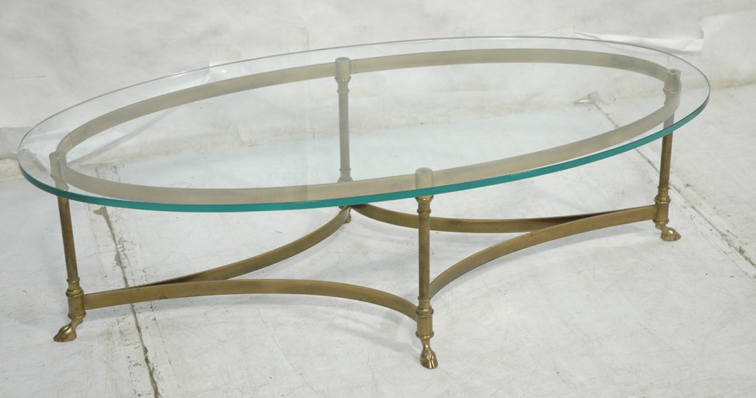 Regency style Brass & Glass Oval Coffee Table. Ho: Regency style Brass & Glass Oval Coffee Table. Hoof feet. 3/4" thick oval glass top. -- Dimensions: H: 15.75 inches: W: 53 inches: D: 26.5 inches ---