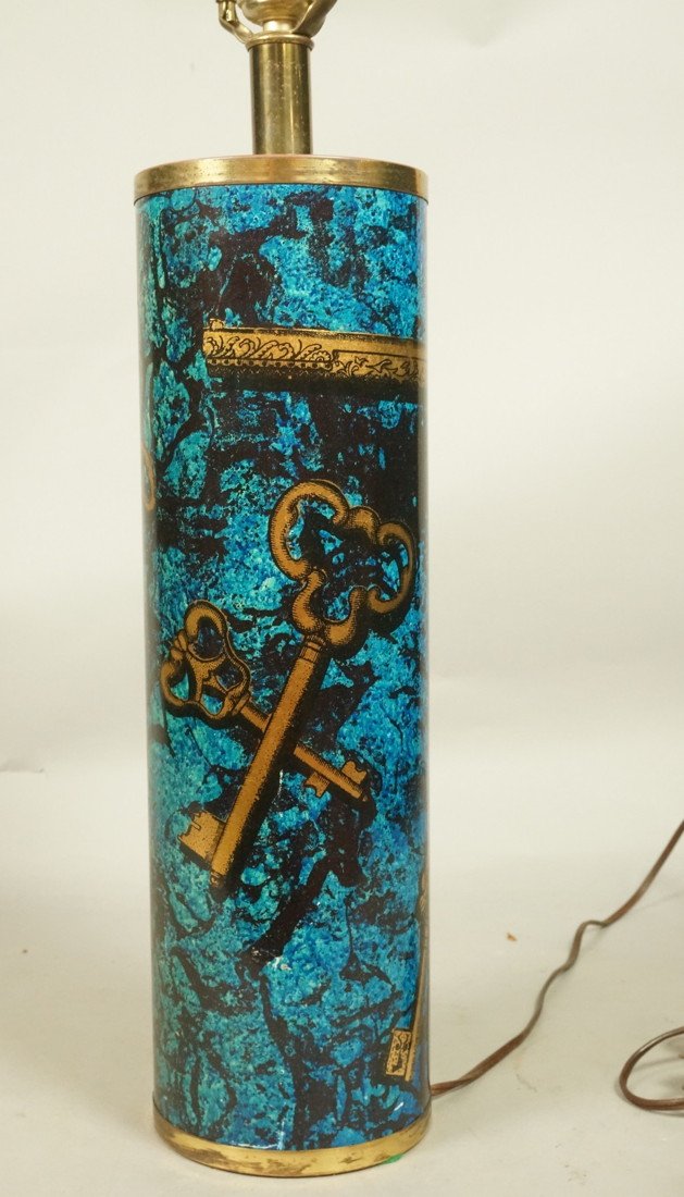 PIERO FORNASETTI style Table Lamp. BUCCIARELLI. M: PIERO FORNASETTI style Table Lamp. BUCCIARELLI. Metal cylinder form with gold keys & gun design. Blue background. Bucciarelli label. ITALY.-- Dimensions: H: 26 inches ---