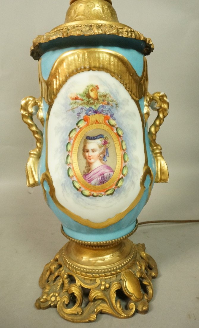 Porcelain Table Lamp with Handpainted Cameo Medal: Porcelain Table Lamp with Handpainted Cameo Medallions. Metallic gold painted trim and handles. Fancy Brass Fittings. -- Dimensions: H: 26 inches: W: 7 inches ---