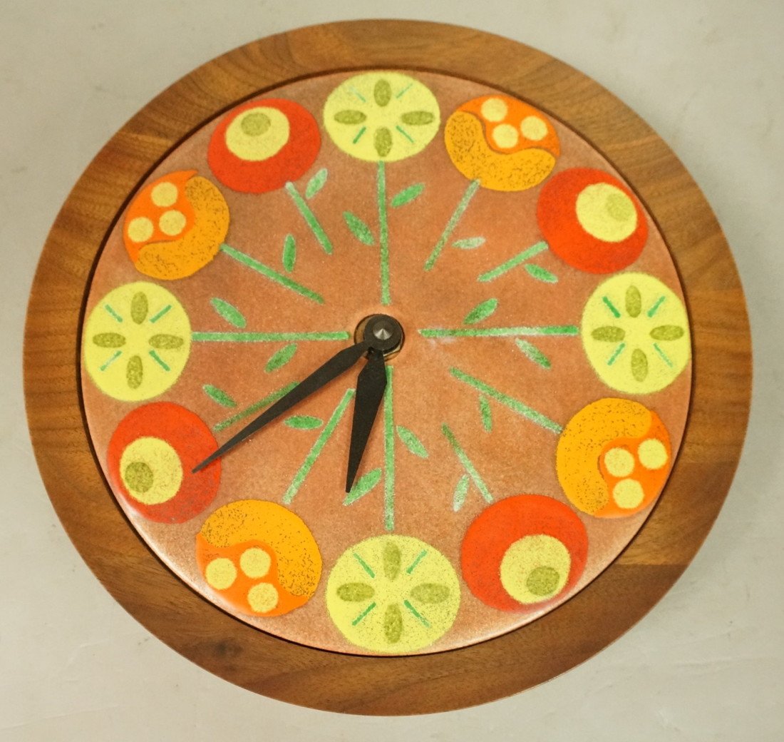 Enamel Face Modernist Teak Wall Clock. Enamel flo: Enamel Face Modernist Teak Wall Clock. Enamel floral design in teak frame. Battery operated.-- Dimensions: H: 9.5 inches: W: 9.5 inches: D: 1.75 inches ---