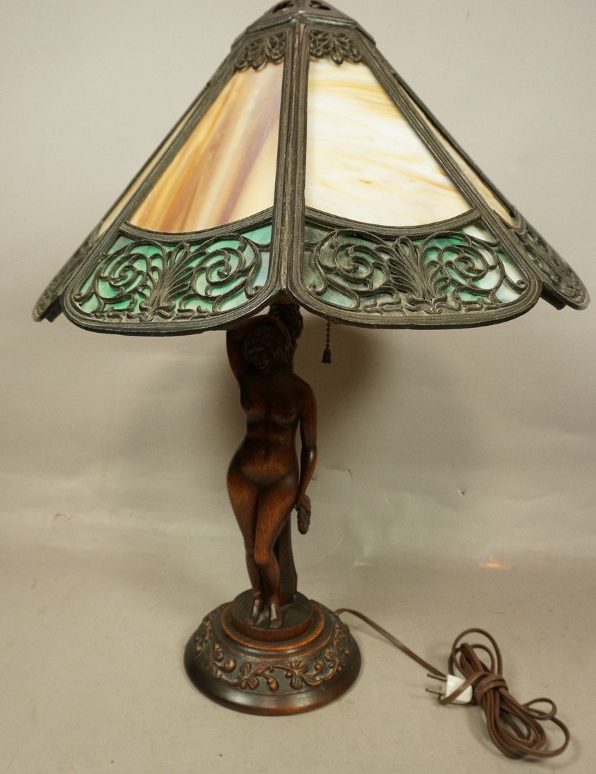 Slag glass table lamp with carved figural wood ba: Slag glass table lamp with carved figural wood base. Female nude carved wood with green and amber slatted glass wood shade. label underneath Scott E. Barwis. October 2, 1928.-- Dimensions: H: 22 inche