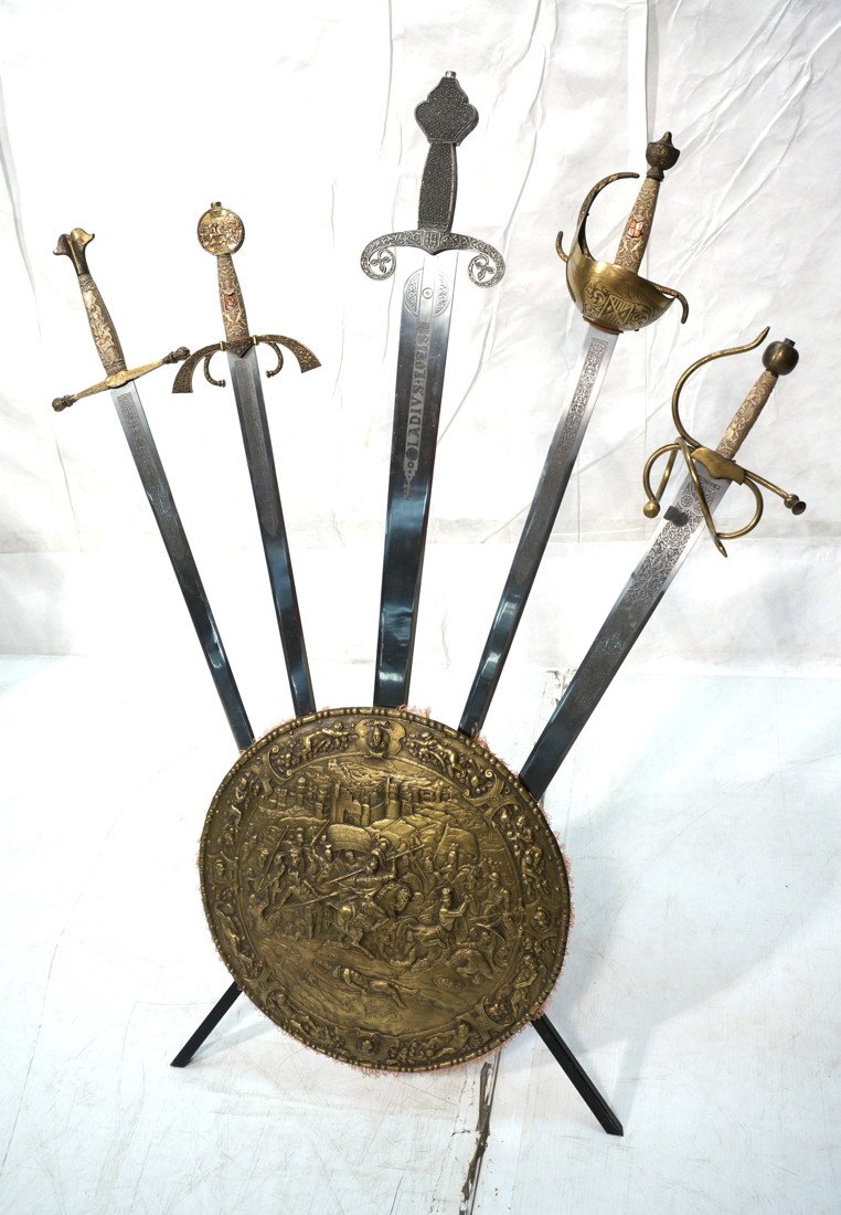 Decorative swords on shield stand base. 5 medieva: Decorative swords on shield stand base. 5 medieval style swords on a circular shield base with iron supports.-- Dimensions: H: 44 inches: W: 35 inches: D: 19 1/4 inches ---