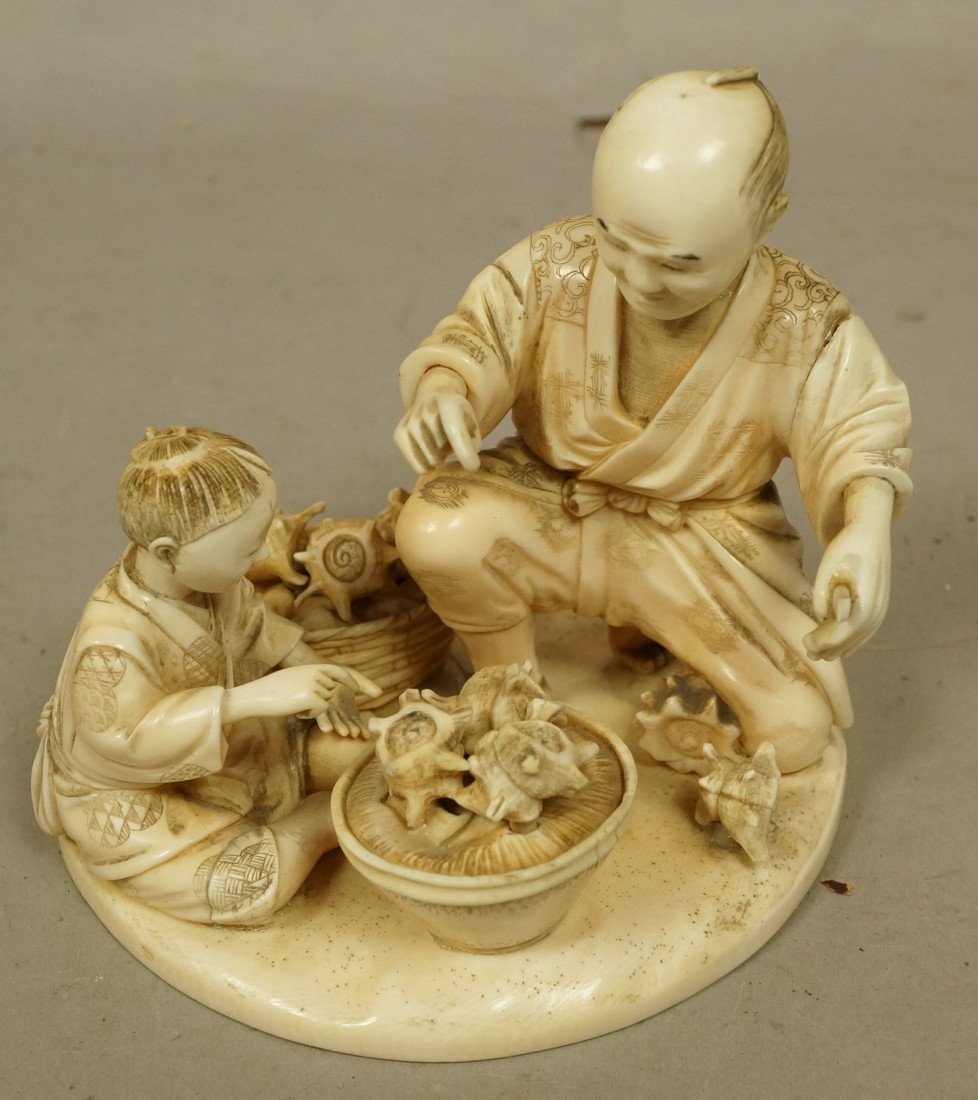 Carved Japanese ivory sculpture man with child an: Carved Japanese ivory sculpture man with child and baskets of seashells. Signed. -- Dimensions: H: 4 inches: W: 4.5 inches: D: 4 inches --- US Shipping charge: $20