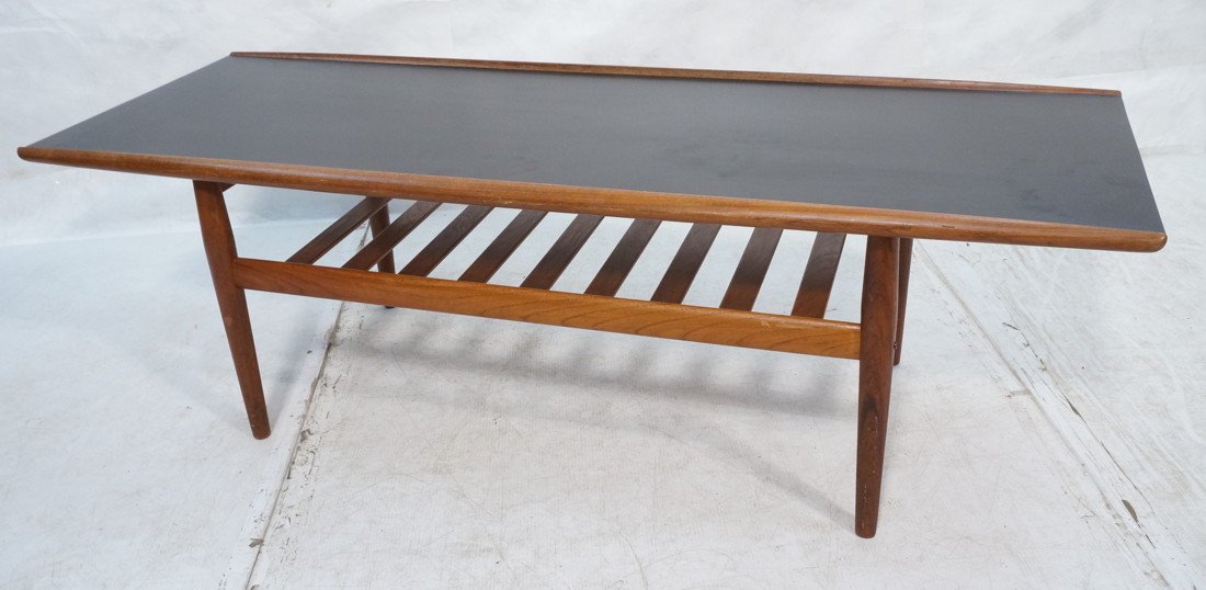 GRETE JALK Danish Rosewood Coffee Table. Flared r: GRETE JALK Danish Rosewood Coffee Table. Flared rolled edges. Black laminate top. Lower slat shelf. Tapered peg legs. Not marked-- Dimensions: H: 20 inches: W: 63 inches: D: 23.5 inches ---