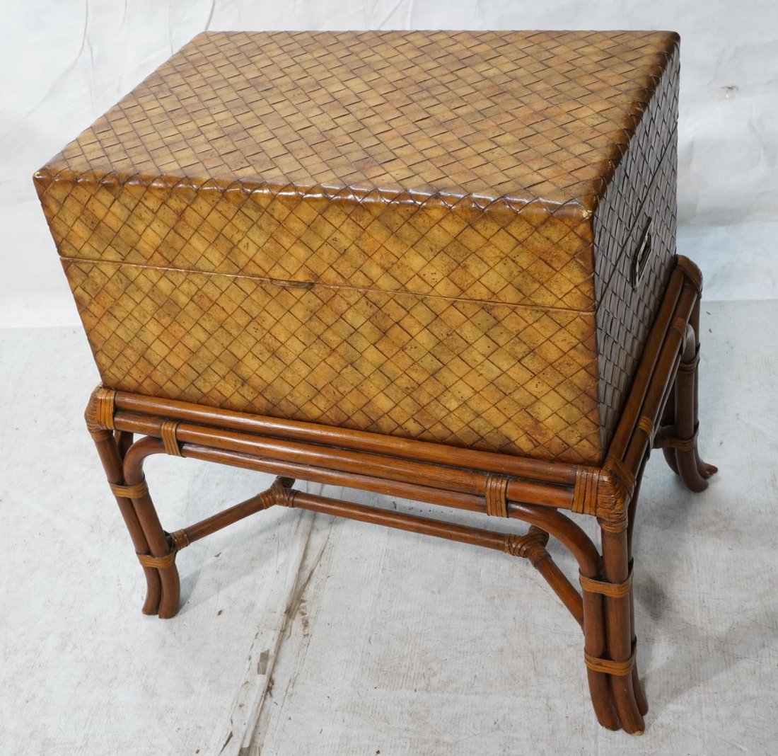 MAITLAND SMITH Trunk on Rattan Base. Woven leathe: MAITLAND SMITH Trunk on Rattan Base. Woven leather trunk with brass handle. Sits on rattan stand. Marked metal tag-- Dimensions: H: 30 inches: W: 30 inches: D: 19 inches ---