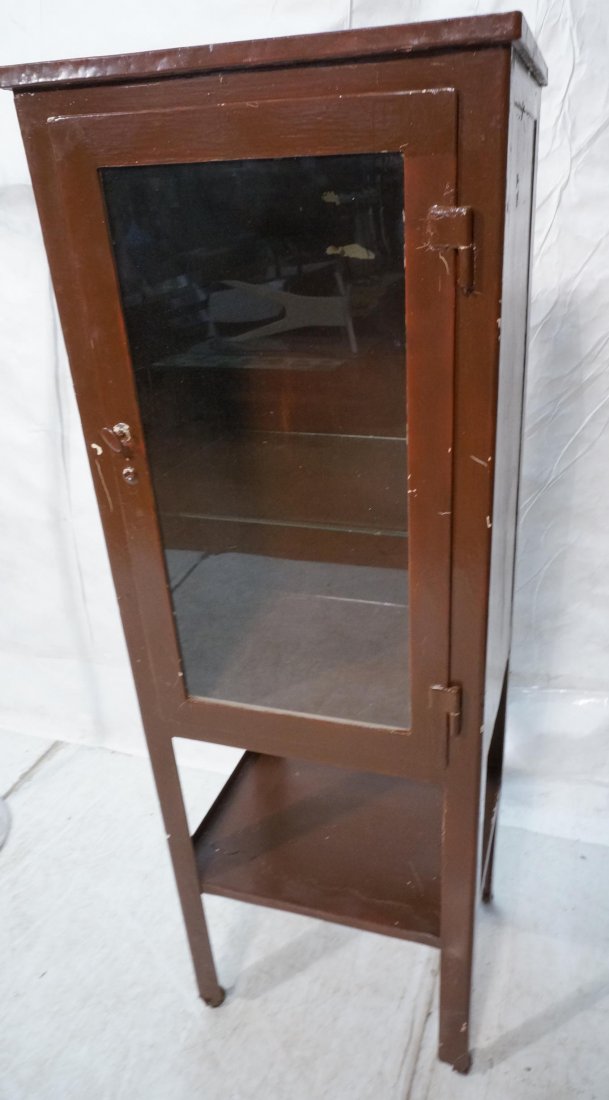 Vintage Metal Medical Cabinet. Raised on legs wit: Vintage Metal Medical Cabinet. Raised on legs with lower shelf. Painted brown.-- Dimensions: H: 60.75 inches: W: 20 inches: D: 15.5 inches ---