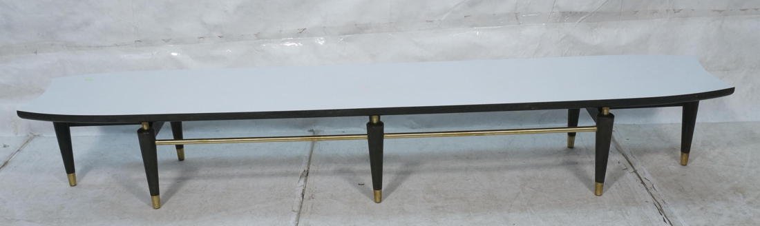 Modernist American White Laminate Top Coffee Tabl: Modernist American White Laminate Top Coffee Table. Bowed sides with clipped edges. Black frame with brass cap feet and supports. -- Dimensions: H: 14.5 inches: W: 96 inches: D: 18 inches ---
