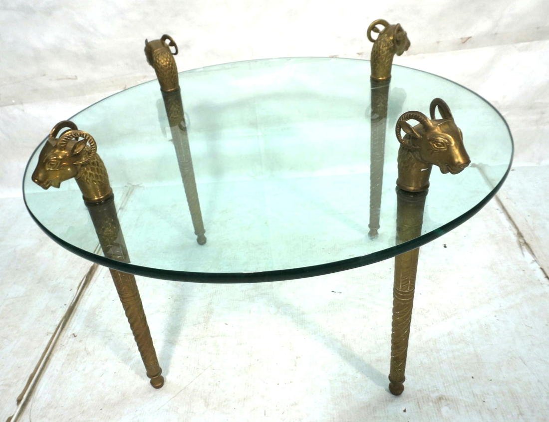Decorator Brass & Glass Coffee Cocktail Table. Ra: Decorator Brass & Glass Coffee Cocktail Table. Rams Head Finials on tooled brass legs. 3/4" thick round glass. Height of table to top of glass is 19.5"-- Dimensions: H: 25 inches: W: 36 inches: D: 36 