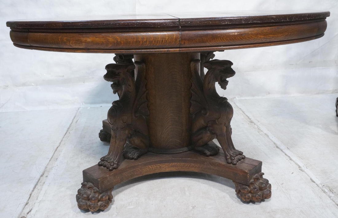 Hastings Oak Dining Table with Full Seated Griffi: Hastings Oak Dining Table with Full Seated Griffin Base. Round dining table with 4 winged griffins and paw feet. Two 10.25 inch skirted leaves and Two 8.5 inch leaves. Tiger Oak.-- Dimensions: H: 29 i