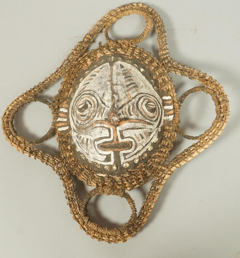 African Mask made with Turtle Shell. Woven Textil: African Mask made with Turtle Shell. Woven Textile webbed trim. Painted face on turtle shell with cowry shell details.-- Dimensions: H: 16 inches: W: 14 inches: D: 3 inches --- US Shipping charge: $35