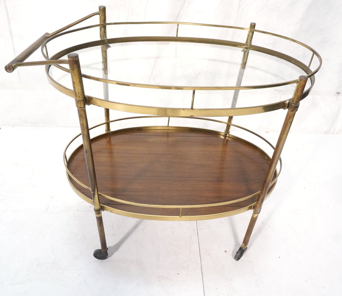 Brass Oval Rolling Tea Bar cart. Two tier brass g: Brass Oval Rolling Tea Bar cart. Two tier brass gallery. Plastic casters. Wood lower level-- Dimensions: H: 30 inches: W: 32 inches: D: 19.5 inches ---