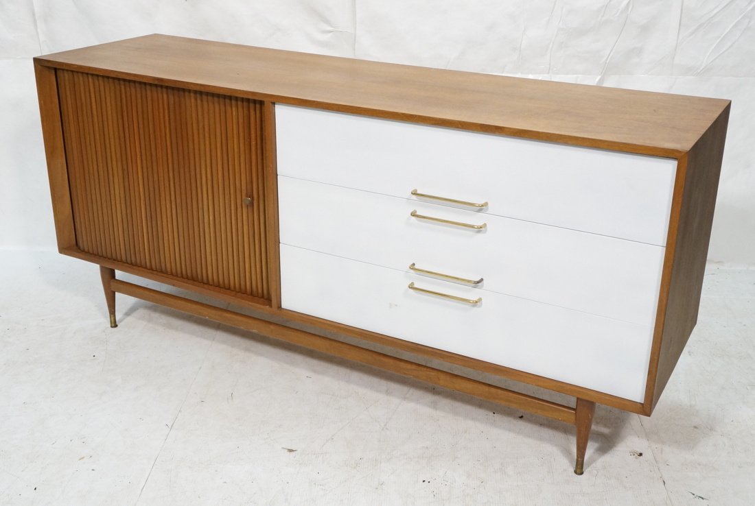 Modernist 3 drawer credenza. One sliding tambour: Modernist 3 drawer credenza. One sliding tambour door. Fitted interior. Brass hardware. Sits on brass capped peg legs with stretcher-- Dimensions: H: 33.5 inches: W: 72 inches: D: 20 inches ---