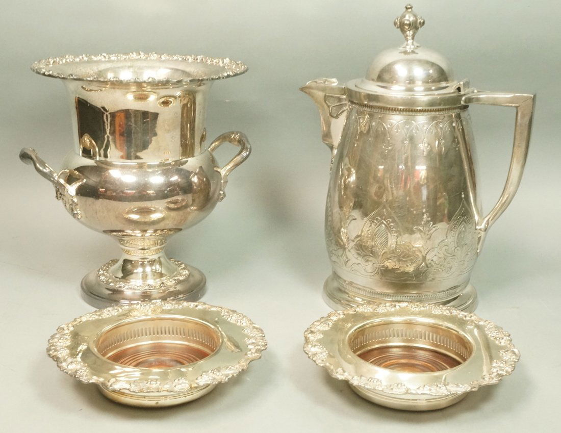 4pc Silver Plate Lot. Large Lidded Pitcher Water: 4pc Silver Plate Lot. Large Lidded Pitcher Water Kettle with detailed engraved details. Footed Champagne Ice Bucket. Two Wide Rimmed Wine Coasters. -- Dimensions: H: 13 inches: W: 10.5 inches: D: 7.25
