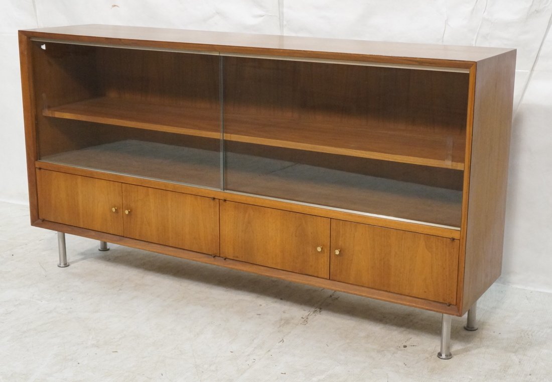 Modernist Sliding Glass Door Credenza. Raised on: Modernist Sliding Glass Door Credenza. Raised on chrome tube legs. Four lower drawers. -- Dimensions: H: 32 inches: W: 60 inches: D: 14 inches ---