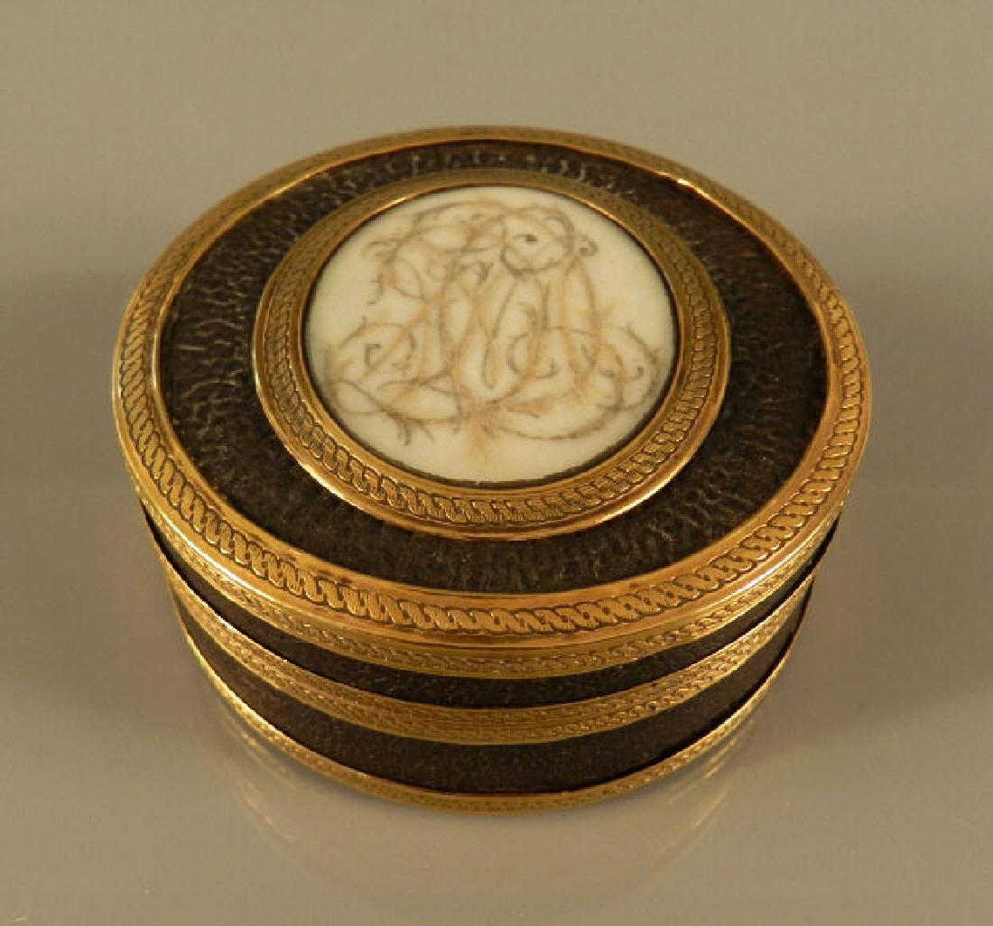 18th Century Memento Mori Circular Box: An 18th C. Memento Mori box, the cover with oval panel and monogram, with pinchbeck bands, h. 1” x dia. 2 1/2”. Une boîte Memento Mori, 18e siècle, le couvercle avec un panneau oval et initiales