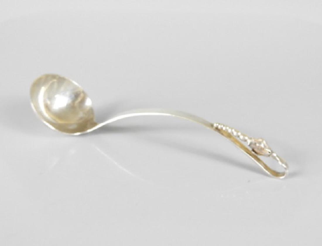 GOOD MEXICAN SILVER LADLE: A good Mexican silver ladle in the Scandinavian taste, the curved handle ending with a stylized floral motif, marked, 100 grams.