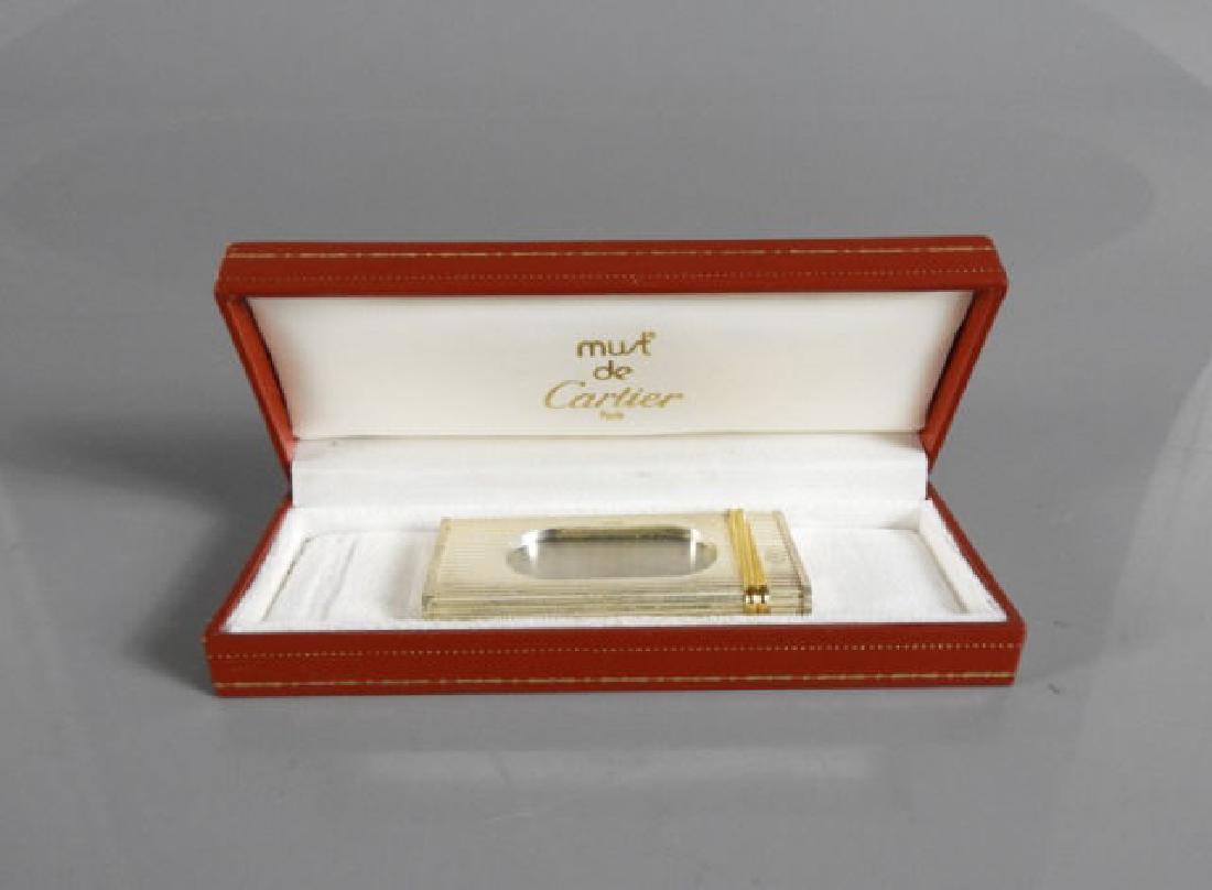 CIGAR CUTTER 18KT GOLD ACCENTS, MUST DE CARTIER: Stainless steel cigar cutter by "Must de Cartier", with the classic "Must" gold accent in 18KT gold, original presentation box.