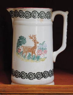 PORTNEUF PITCHER / PICHET PORTNEUF: Portneuf pitcher with multi-colour sponge decorated deer motif. 19th century. Ex collection: Marjorie McConnell. Illustrated: Celebrating Canada, page 24. H: 8.5"; D: 4". Condition: chip on base