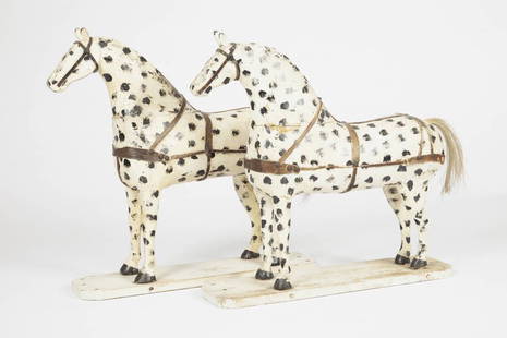 TOY APPALOOSA HORSES / JOUETS-CHEVAUX APPALOOSA: Pair of hand carved child's toy horses in Appaloosa markings of dappled black on white, with original leather harness. Quebec, early 20th century. H: 17"; L: 17". // Paire de chevaux-jouets