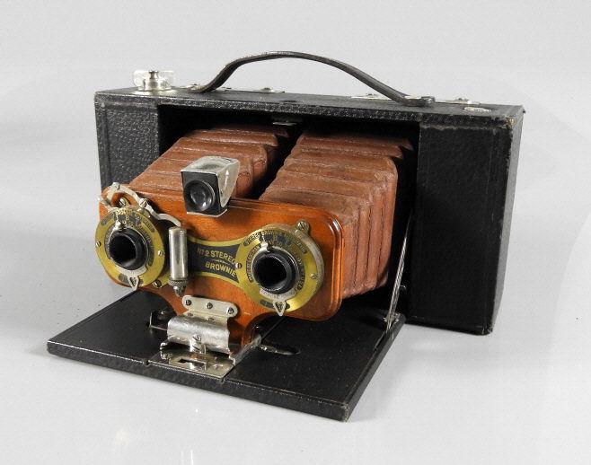 EASTMAN KODAK STEREO BROWNIE AUTOMATIC CAMERA: Eastman Kodak No. 2 Stereo Brownie Automatic camera. Folding-bed stereo camera for 10cm wide roll film, unmarked lenses. Distinctive red bellows. With original carrying case and strap. Very good condi