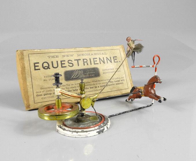MECHANICAL EQUESTRIENNE TOY: The new Mechanical "EQUESTRIENNE”, manufactured and patented by â€œW. Britain”. Pat No. 17,258. A string is used to spin the flywheel. When the horse arrives at the jump, a cam lug is 