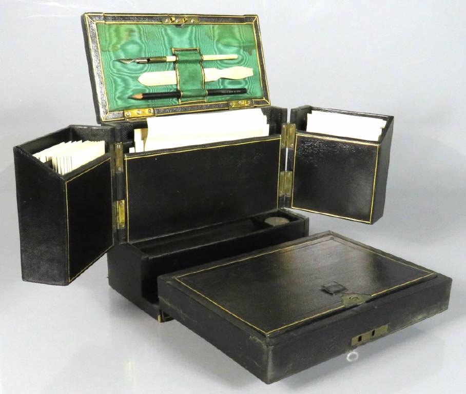 LATE VICTORIAN LEATHER BOUND COMPENDIUM: A late Victorian leather bound travelling writing compendium, the hinged case opening to reveal various stationary compartments, fitted with a carrying handle and functioning lock mechanism and key, i
