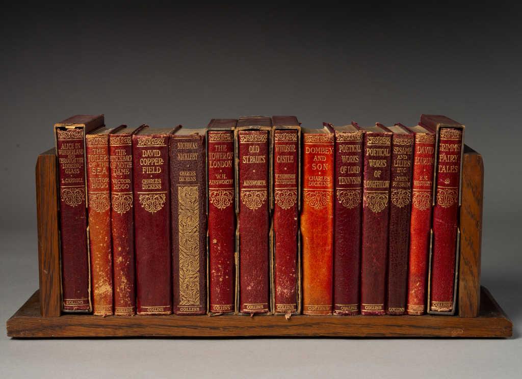 BOOKS - 14 NOVELS & CARVED OAK FOLDING BOOK RACK: Fourteen books, red soft leather bindings. Published by, Collins, London. (1) Alice in Wonderland and Through the Looking Glass. (2) The Toilers of The Sea. (3) The Hunchback of Notre Dame. (4) David