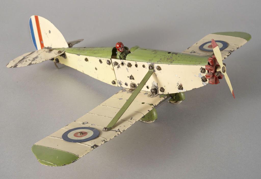MECCANO AIRPLANE MODEL, CIRCA 1930: A Meccano model airplane, cream and green paint, with RAF roundels, dihedral wing, rotary engine and original pilot. Aerodynamic wheel guards. Circa 1930. Dimensions, 4" x 19" x 15".