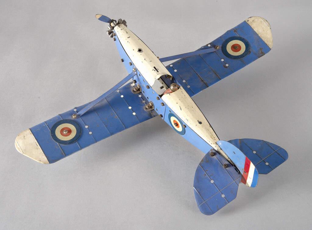 MECCANO AIRPLANE MODEL, CIRCA 1930: A Meccano airplane model, blue with white paint with RAF roundels, dihedral wing, rotary engine and original pilot. Aerodynamic wheel guards. Circa 1930. Dimensions, 5" x 18" x 15".