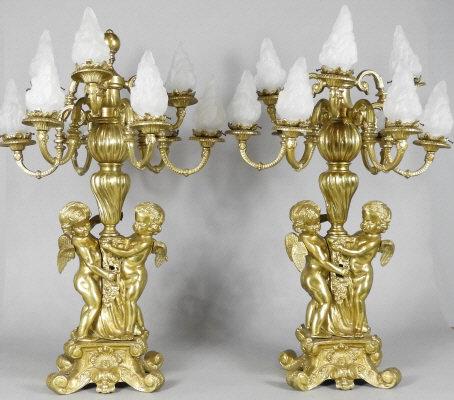 VERY LARGE PAIR OF FRENCH GILT BRONZE CANDELABRAS: A very large pair of French gilt bronze candelabras. Each with 9 branches, supported by a withering central column and 2 standing cherubs, resting on a scrolling pedestals. Dimensions, 32.5" x 22".
