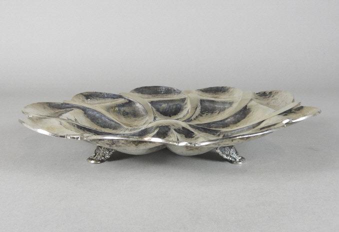 AUSTRIAN SILVER OYSTER PLATTER: A mid 19th century Austrian silver oyster platter, showing a planished surface and 9 scalloped segments, raised upon shell embossed scrolled supports. Marks on exterior rim noting .800 fine, and date 