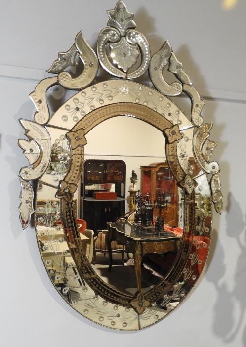 VENETIAN STYLE GLASS WALL MIRROR: A large 20th century Venetian style glass wall mirror, the shield shaped frame decorated with hand applied scrolling segments accented with frosted detail. Dimensions, 46" x 30".