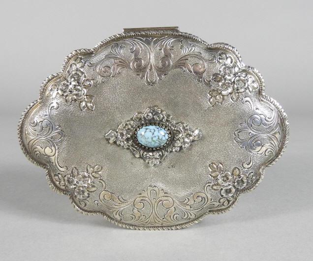 ITALIAN SILVER JEWELLERY BOX WITH CABOCHON: An early 20th century Italian silver jewellery box, the lobed body having a hinged conforming lid decorated with foliate engraved and embossed motifs, centered by a mottled turquoise cabochon and open
