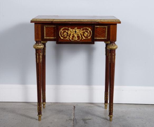 LOUIS XVI STYLE MAHOGANY SIDE TABLE: A mid 20th century Louis XVI style mahogany and parquetry side table, showing a parquetry top inlaid with ebony and basswood stringing within a cross banded border of mahogany and kingwood, ormolu mol