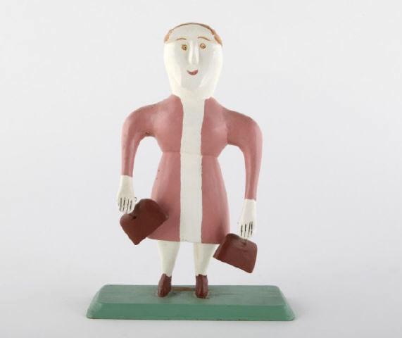 Sculpture of Lady in Pink, Charlie Tanner: A sculpture of a lady in pink dress holding two bags by Charlie Tanner, Nova Scotia. Inscribed in pencil on the bottom: "The Visitor, Charles E. Tanner, Eagle Head, NS, 1981". Purchased directly from