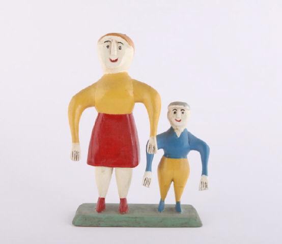Woman & Boy Carving, by Charlie Tanner, 20th C.: A carving by Charlie Tanner, Eagle Head, Nova Scotia, of a woman and boy with typical dropped arms and colourful paint. 3rd quarter 20th century. H: 11"; W: 7"; D: 3".