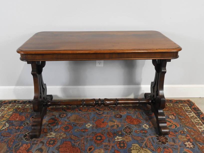 Mahogany Sofa Table, Ca. 1900: A late 19th century mahogany sofa table, the rectangular shaped top raised on a trestle base with pierced supports on brass castors braced by a turned stretcher. Circa 1900. Dimensions, 28" h x 41" w