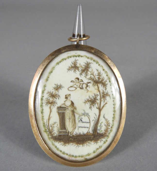 French Remembrance 14KT Gold Locket: An extremely fine early 19th century French remembrance 14KT gold locket executed in watercolour and gilt pique-work, depicting a cherub descending with a wreath to a woman holding an oval cartouche i